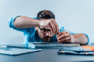 man fixing laptop for business IT sustainability