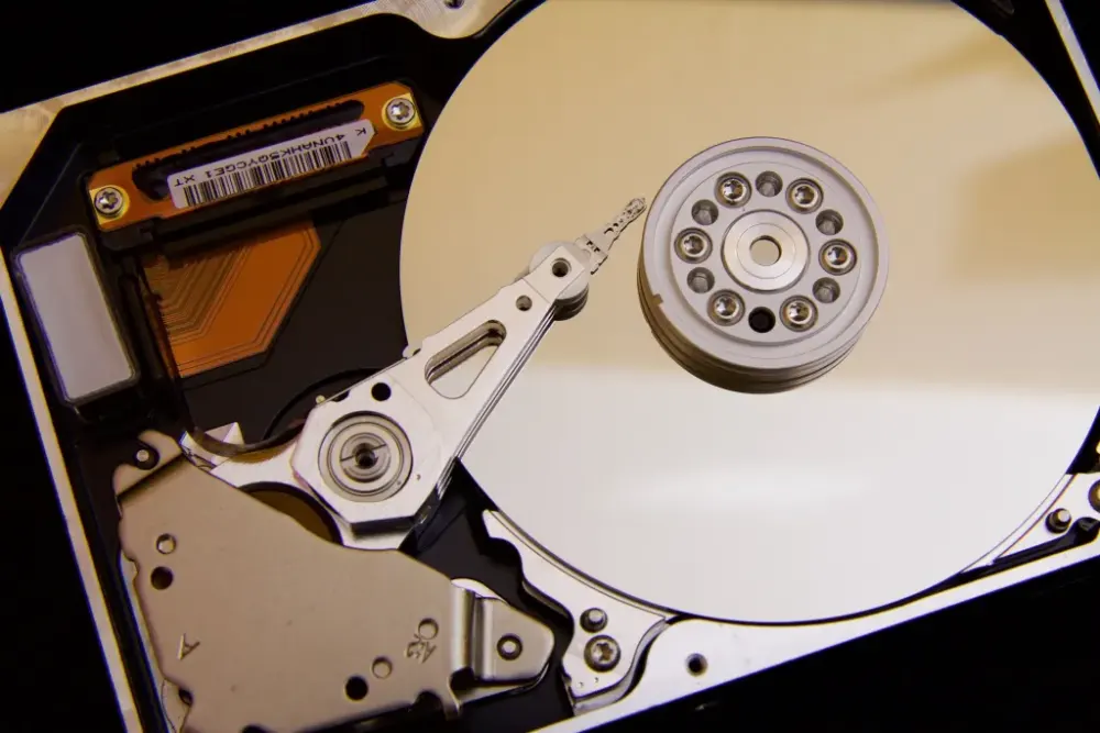 The inside of a hard disk – the metal plate spins so that the reader (on the arm) can access the data
